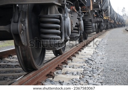 A closeup of the wheels of black old train on the railway track