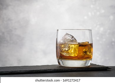 Close-up whiskey with ice cubes on gray background with copy space - Powered by Shutterstock