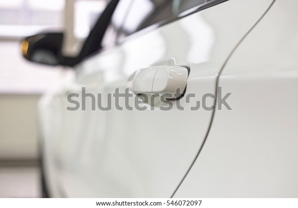 Close-up of white car in\
repair store