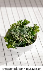 Close-up Of White Ceramic Bowl Full Of Healthy Veggie Chips Made Of Kale With Pepper And Olive Oil.Low-carb And Gluten Free Vegetable Crisps Snack