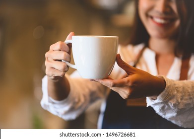 Closeup Of White Coffee Cup With Beautiful Asian Woman Barista Background For Serving To Customer. Job And Occupation. Food And Drink Beverage. Coffee Shop And Cafe. Business And Restaurant Ownership