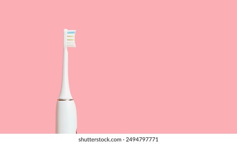 Close-up of white electric toothbrush on pink background. Copy space for text. Concept of oral hygiene, dentistry, health - Powered by Shutterstock