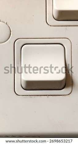 Close-Up of White Electrical Switch on Plastic Plate Showing Signs of Wear and Recessed Frame Design