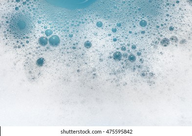 closeup to white foam on blue water