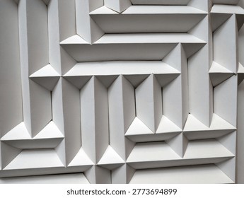 Close-up of a white geometric labyrinthine pattern, emphasizing texture and depth through lighting.