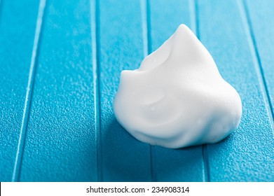 Closeup White Hair Mousse On Blue Background