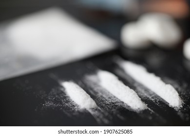 Closeup of white narcotic powder tracks on black background. Opioid addiction concept