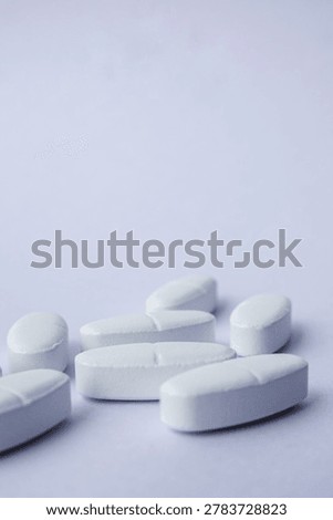 Close-up of White pharmaceutical tablets placed on a soft purple background. Medical and healthcare concept representing medication, treatment, pharmacy, antibiotics, pain relief, and modern pharmaceutical industry with minimal stayle and copy space.