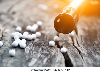 Closeup of white plastic bullets of airsoft gun or bb gun on wooden floor, soft and selective focus on white bullets.