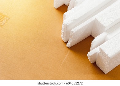 Closeup white polystyrene foam on the cardboard. Polystyrene foam is cushioning material in packaging, material for craft applications and other. - Shutterstock ID 604551272