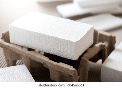 Closeup White Polystyrene Foam On Corrugated Paper. Polystyrene Foam Is Cushioning Material In Packaging, Material For Craft Applications And Other.