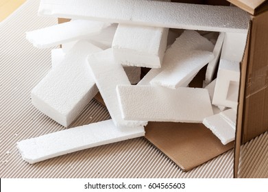 Closeup white polystyrene foam in parcel box. Polystyrene foam is cushioning material in packaging, material for craft applications and other.