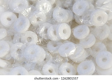 Closeup Of White Round Mints Inside Individual Clear Packages