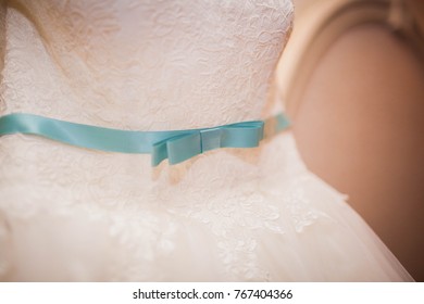 Closeup Of White Wedding Dress With Blue Ribbon