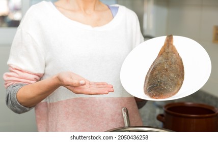 Closeup Of Whole Fresh Black Sole Fish On Plate In Hands Of Woman..