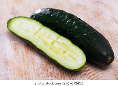 Closeup of whole and halved fresh cucumbers on wooden surface. Healthy vegetarian ingredient - Powered by Shutterstock