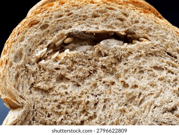 Close-Up Whole Wheat Bread Slice with Nut Filling. Close-up of a sliced whole wheat bread loaf revealing a rich nut filling and detailed crumb texture.                               