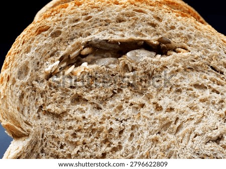 Close-Up Whole Wheat Bread Slice with Nut Filling. Close-up of a sliced whole wheat bread loaf revealing a rich nut filling and detailed crumb texture.                               