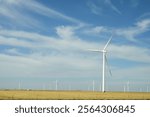 A close-up of a wind turbine in the Texas Panhandle, showcasing the large blades against the clear sky, symbolizing renewable energy and sustainable farming practices in the region.