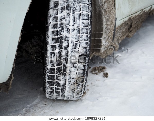 Close-up of a\
winter car tire tread with snow and ice. The use of special tires\
in the winter season is the basis for safe braking and\
acceleration. High-tech rubber\
compound.