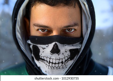Closeup Winter Portrait Of The Man With Expressive Eyes In The Hood And Mask With Skull - Anonymous Rebel. 