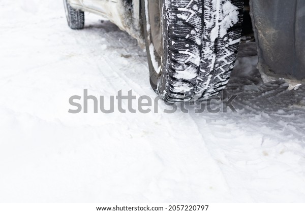 Closeup winter tire. Car tires on the road covered\
with snow