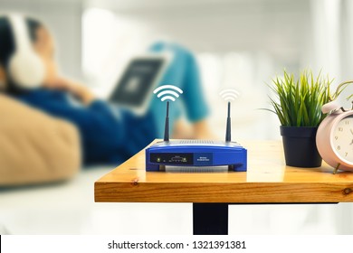 closeup of a wireless router and a man using smartphone on living room at home ofiice