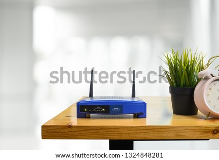 closeup of a wireless router and a man using smartphone on living room at home ofiice