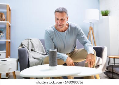 Close-up Of Wireless Speaker In Front Of Man Sitting On Sofa