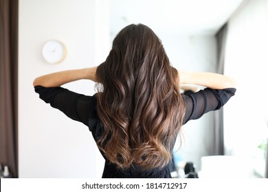 Close-up of woman after visiting hairdresser. Long curls of brunette female person. Hairdo for holiday or for everyday. Beauty salon and hairstyle concept - Powered by Shutterstock