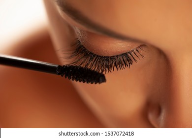 Closeup Of Woman Applying Mascara On Her Eyelashes