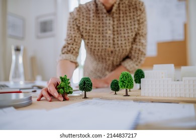 Close-up of woman architect with model of houses in office