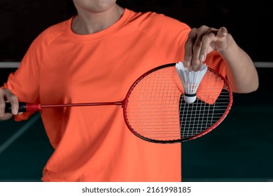 Closeup woman Badminton player holding Badminton racket and shuttlecock preparing to serve in court, sporty female athlete's hands serving badminton ball, most popular indoors sport game concept
