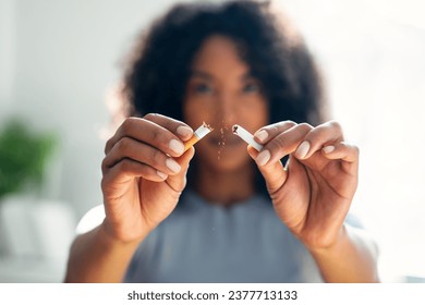 Close-up of woman breaking down cigarette to pieces. Quit smoking concept - Powered by Shutterstock