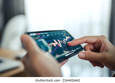 Closeup - Woman is checking Bitcoin price chart on digital exchange on mobile smartphone, cryptocurrency future price action prediction.