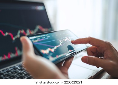 Closeup - Woman is checking Bitcoin price chart on digital exchange on smartphone, cryptocurrency future price action prediction. - Shutterstock ID 2200623291