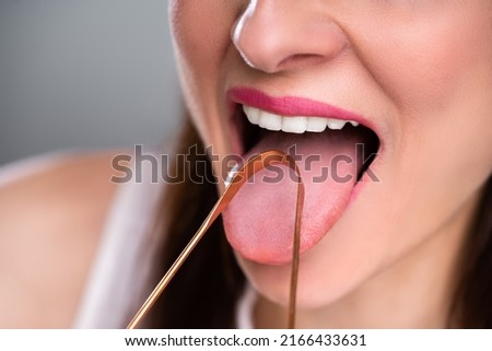 Close-up Of A Woman Cleaning Her Tongue With Cleaner