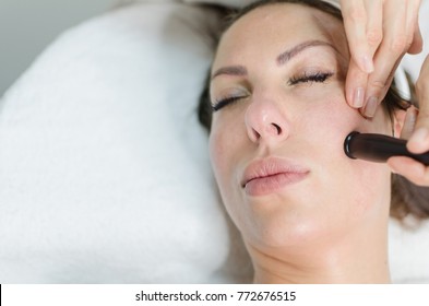 Closeup Of Woman With Closed Eyes Enjoying In Face Treatment With Radio Waves Face Lifting In Dermatologist Office. Space For Text, Copy Space. Face Lifting Mesotherapy Without Needles On Female Face