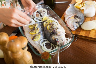 Close-up Of Woman Cooking Fish  In Frying Pan At Home Kitchen 