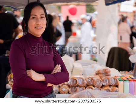 Close-up of a woman crossing her arms offering dairy products and almojábanas at a gastronomic fair. Concept of typical Colombian food. Stock foto © 