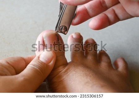closeup of a woman cutting nails by nail clipper. 