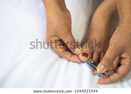 closeup of woman cutting toenails.