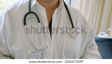 closeup woman doctor wearing white medical coat and stethoscope, doctor prepares to examine the patient in the office, holds a part of the stethoscope in his hand