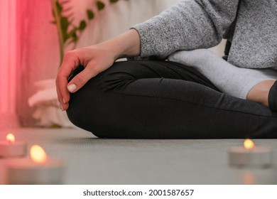 Close-up. Woman Doing Yoga Exercise At Home. Mindfulness Meditation. Relax Breathe Easy Pose Gym Healthy Lifestyle Concept. Burning Candles Light. Lotus Asana. Atmosphere Of Relax And Zen.