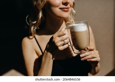 Closeup Of A Woman Drinking Coffee From A Transparent Double Glass Cup, In Sunlight, Smiling.