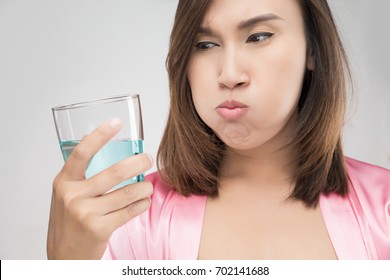 Close-Up Of Woman Drinking Water While Standing Against Wal, People Rinsing And Gargling While Using Mouthwash From A Glass - Dental Healthcare Concepts - Powered by Shutterstock