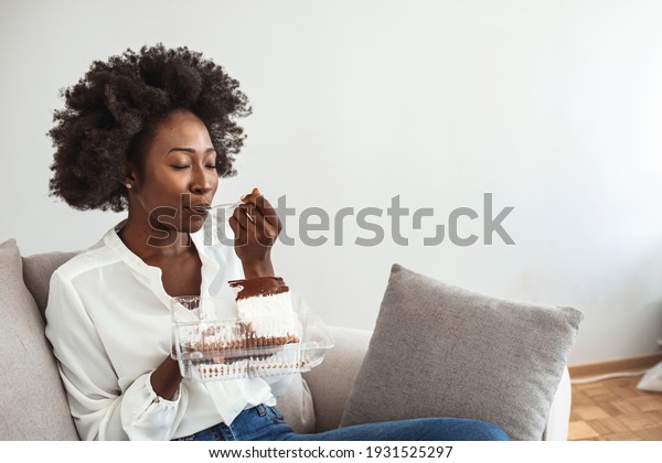 Closeup of woman\
eating cake. Beautiful girl enjoys eating a cake with chocolate.\
Pretty young woman eats a sweet cake. food, junk-food, culinary,\
baking and holidays concept.\
