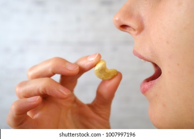 Close-up Of Woman Eating Cashew Nuts