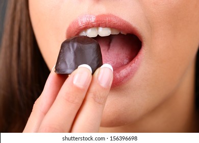 Closeup Of Woman Eating Chocolate Candy 