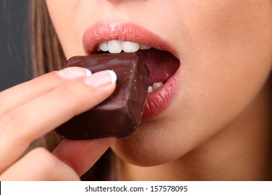 Closeup Of Woman Eating Chocolate Candy 